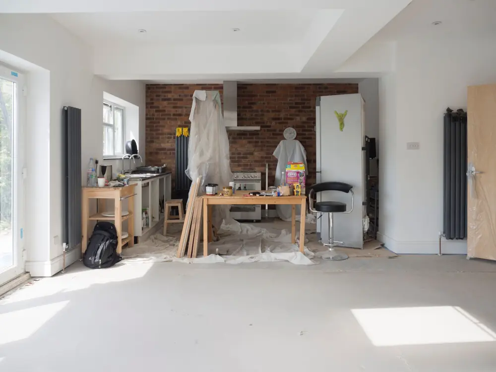 Antes: Planta abierta en plena obra con muebles protegidos y herramientas (imagen de muestra)