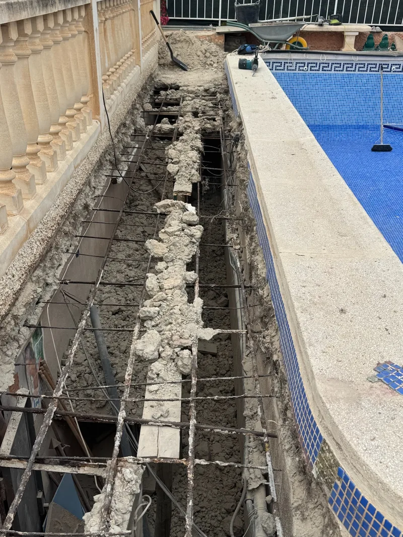 Antes: Pasillo junto a la piscina demolido, con la ferralla y los escombros a la vista