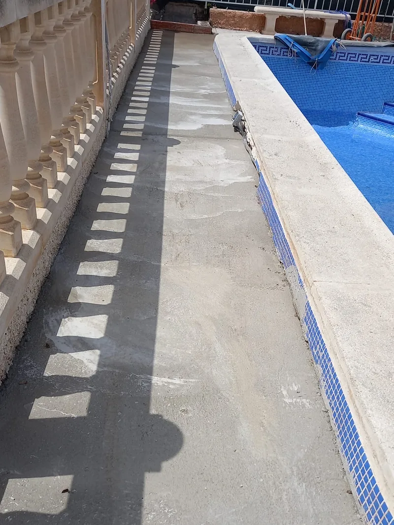 Después: Pasillo junto a la piscina rehecho con una losa nueva de hormigón entre la balaustrada y el vaso