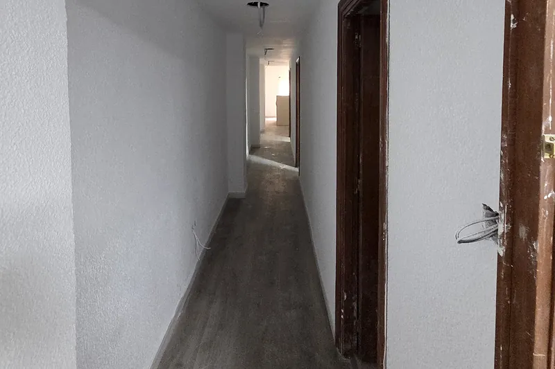 Pasillo de una vivienda reformada, recién pintado y con suelo laminado nuevo